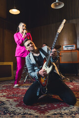 Guitar solist playing solo on his knees and a singer singing during the rehearsal. High quality...
