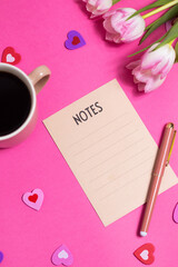 Notes with pen, cup of coffee, tulip spring flower and cute hearts on pink background, flat lay
