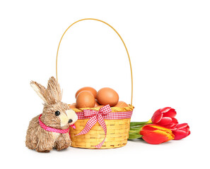 Wicker basket with Easter eggs, tulip flowers and bunny isolated on white background