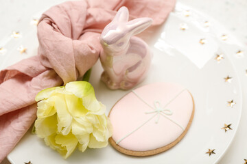 Table setting with Easter egg, bunny and tulip flower on white background