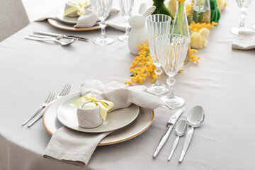 Festive table setting with painted eggs and flowers served for Easter celebration