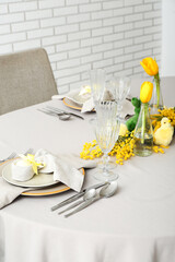 Festive table setting with painted eggs and flowers served for Easter celebration