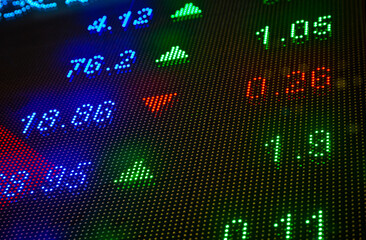 Fototapeta premium Financial stock exchange market display screen board on the street with and city light reflections, selective focus