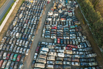 Aerial view of big parking lot of junkyard with rows of discarded broken cars. Recycling of old vehicles