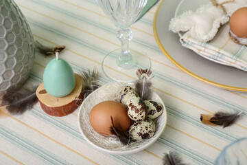 Different eggs and feathers in plate served for Easter celebration