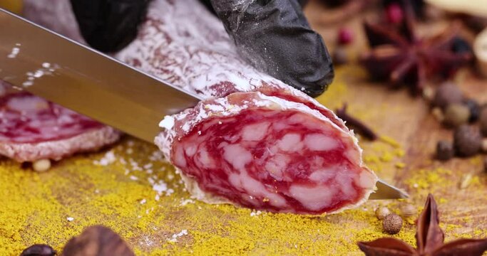 Slicing pork sausage with white mold , dried meat with spices and in white mold close - up