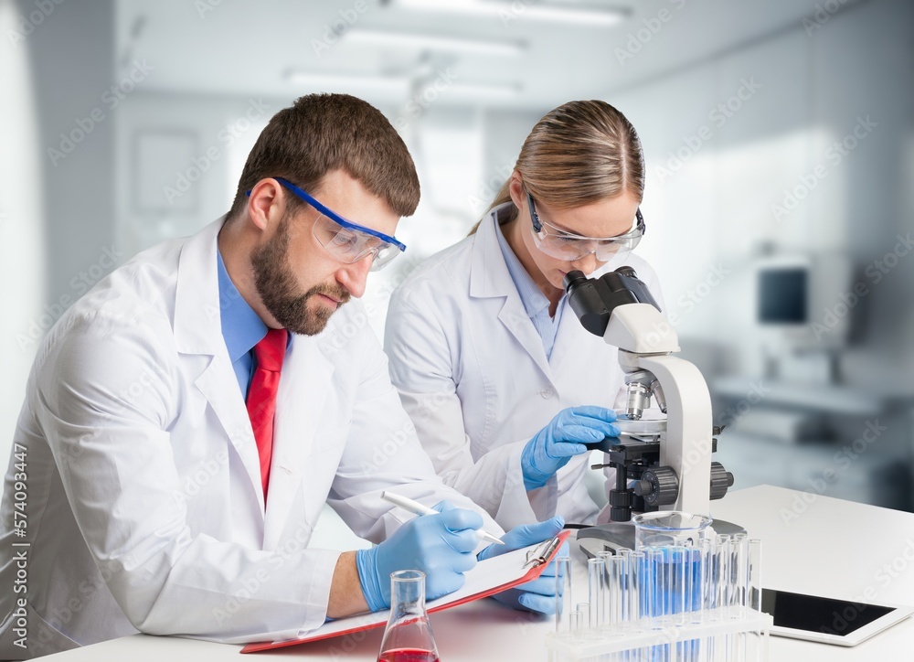 Poster young smart scientist working with microscope in the lab