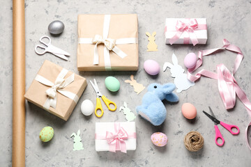 Fototapeta na wymiar Gifts with Easter eggs and materials on grunge background