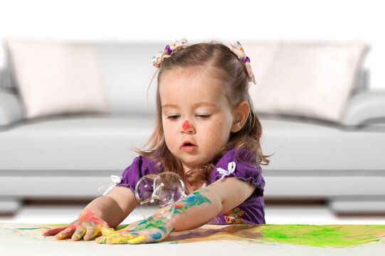 Cute little child drawing on floor at home