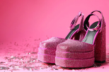 Fashionable punk square toe ankle strap pumps and confetti on pink background, space for text. Shiny party platform high heeled shoes
