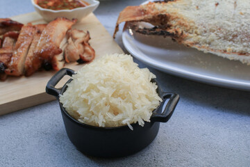 Sticky rice eating with sweet pork grilled and and papaya salad. Traditional asian food. Thai cuisine is so yummy.
