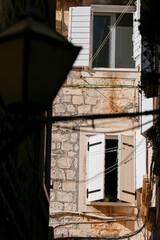 Fototapeta na wymiar Picturesque narrow street with stone houses. Trogir, Dalmatia, Croatia, Europe