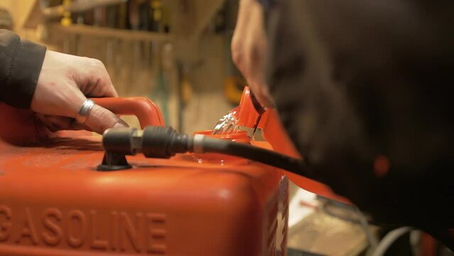 Pouring petrol into petrol tank for boat
