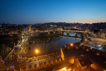 Widok na rzekę Tyber i oświetlone mosty. Widok z okna murów zamku świętego Anioła