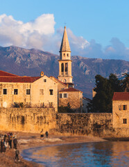 Fototapeta premium View of Budva old town streets, Budva Municipality and Riviera, resort on the Adriatic sea coast, Montenegro, sunny day with a blue sky, cathedral and citadel, travel to Montenegro