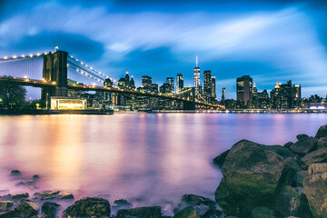 New York city skyline at night and Brooklyn bridge with river