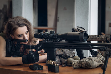 female military sniper with sniper rifle ready to shoot.