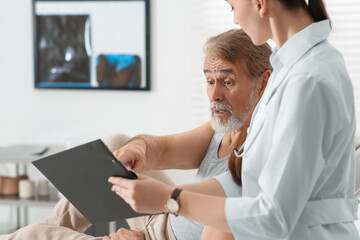 Obraz premium Doctor showing medical card to patient in clinic