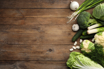 Different fresh ripe vegetables on wooden table, flat lay. Space for text