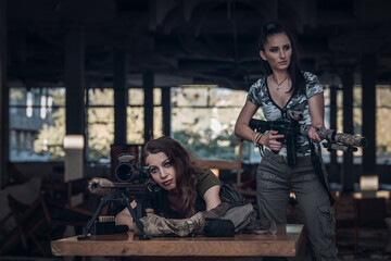 two women with screws in an abandoned building ready to shoot.