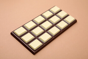 One tasty chocolate bar on brown background