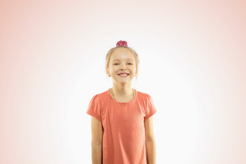 Portrait of a happy smiling child girl on pink background.