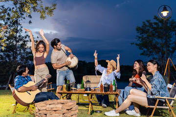 Group of diverse friend having outdoors camping party together in tent. 