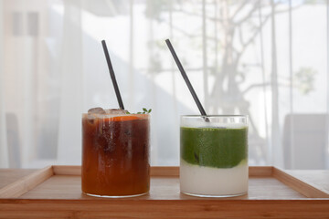 Iced americano with orange and iced matcha green tea in coffee shop