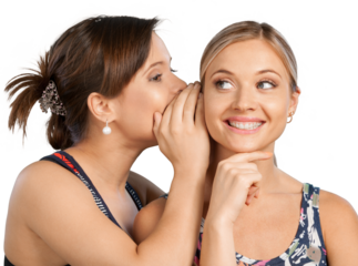 Two happy young girl friends talking or whispering, isolated on white background