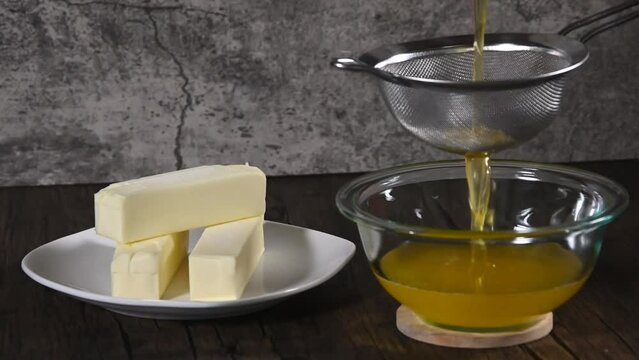 Home made clarified butter also called as Ghee straining it through a fine mesh strainer