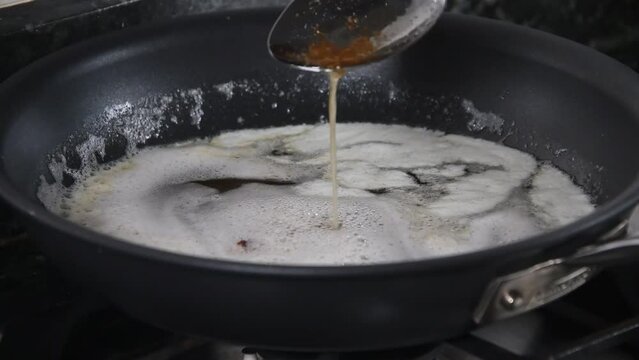 Home made Ghee ready to cool down.  Milk solids in golden brown at bottom of the pan, Clarified butter in middle and foam formed on top.