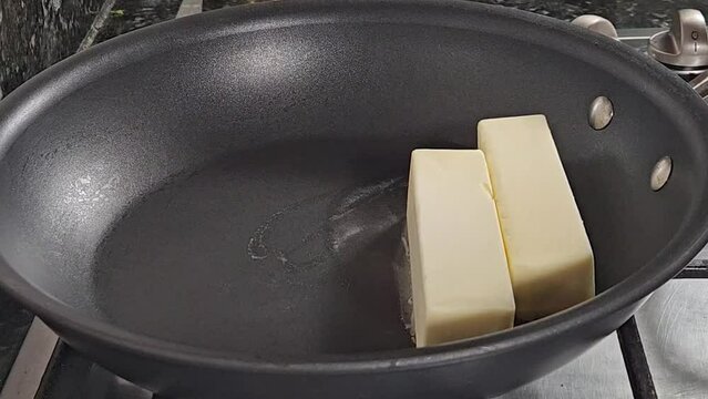 Melting butter sticks to make home made clarified butter also called as Ghee a main ingredient in many India recipes , desserts and sweets.