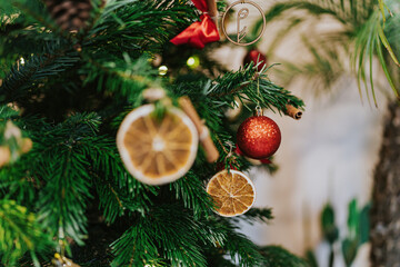 Christmas Tree branches decorated with berries, ribbon, star, pines and red balls