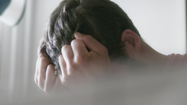Close up shot of a Depressed Caucasian Man Covering His Face at home
