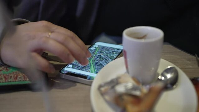Close-up Detail of woman using Google Maps on phone at cafe place