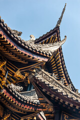 Traditional Chinese architecture details against clear blue sky in BaoLunSi temple Chongqing, China - 574125263