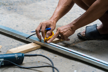 Close-up of man's hand using iron cutter in the workplace, fastening the iron canopy frame with spark