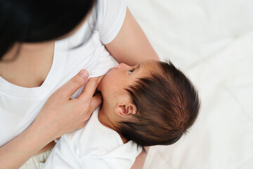 Obraz na płótnie Canvas mother breastfeeding newborm baby on bed