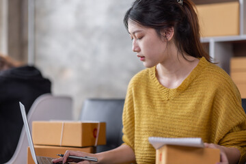 Portrait of Online business owner Asian female small businesses SME entrepreneur working at home, online marketing, packing boxes, SME sellers, concept, e-commerce team, online sales.