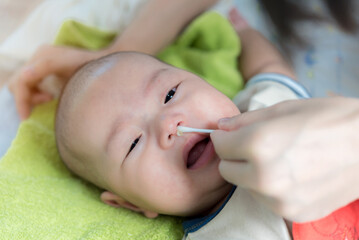 Cleaning Baby Nose With cotton swab, Mother using cotton swap pick up nose a newborn baby