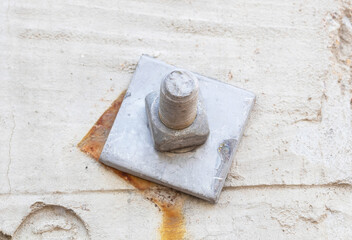 Old Metal male square nut screw nail heads attached concrete cement plinth. To attach structure of wall to be strong for wall of house or various industrial applications. Bolts and screws.