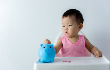 Asia baby boy saving money for future concept on white background, Happy baby with a piggy bank