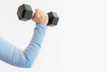 Female hand holding an iron dumbbell on white background, copy space.