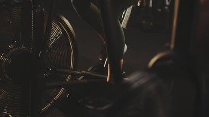Legs and feet in cycling at gym on stationary bike for healthy cardio workout in slow-motion, exercise or training. Leg and foot of sporty athlete riding