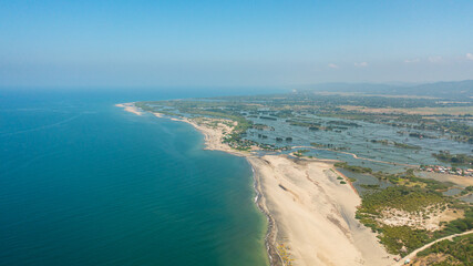 Coastline with fishing villages and fish farms. Luzon, Philippines.