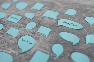 pronouns she her he him and they them in blue speech bubbles surrounded by other empty or anonymous...