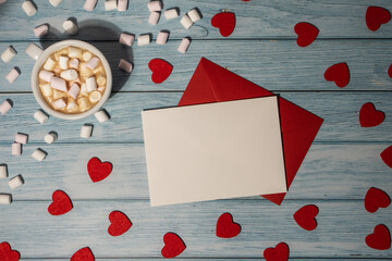 Greeting or invitation card mock up with red envelope with white cup of coffee and marshmallows on wooden background. Romantic Small hearts Valentine day. Blank paper card copy space