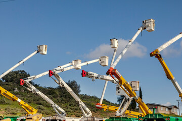 Manlift boom arms for utility work or trtee trimming against a blue sky © F Armstrong Photo