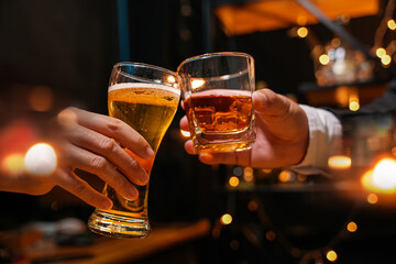 food and drink male friends are happy drinking beer and clinking glasses at a bar or pub.