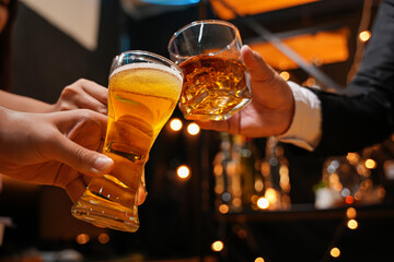 food and drink male friends are happy drinking beer and clinking glasses at a bar or pub.
